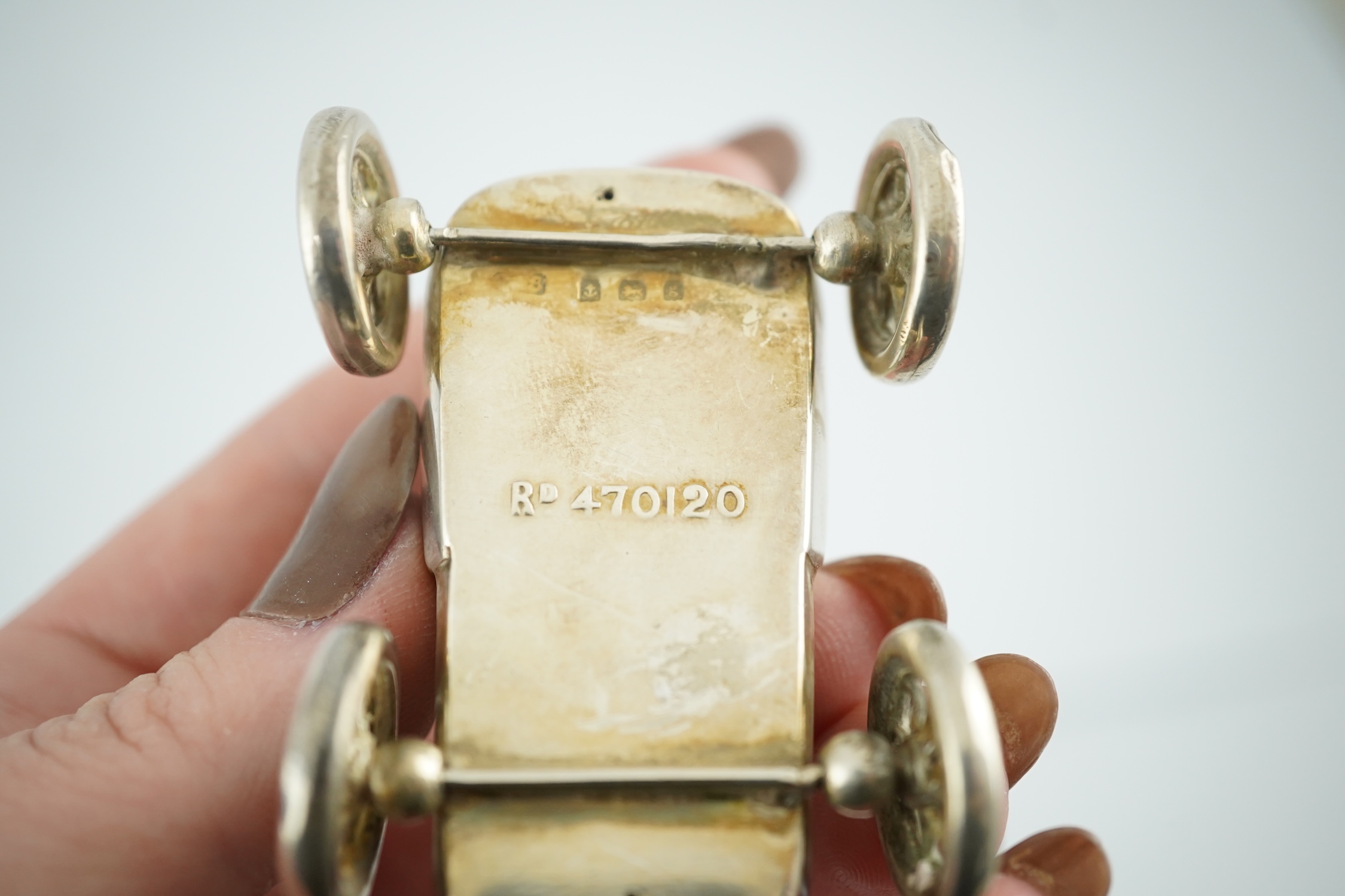 An Edwardian novelty silver mounted pin cushion modelled as a vintage car, makers mark rubbed, Birmingham, 1906, 57mm. Condition - poor to fair